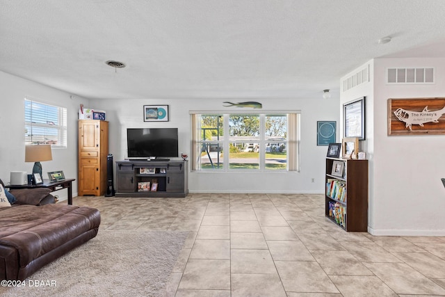 living room featuring light tile patterned floors and a textured ceiling