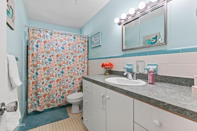 bathroom featuring tile patterned floors, a shower with curtain, vanity, tile walls, and toilet