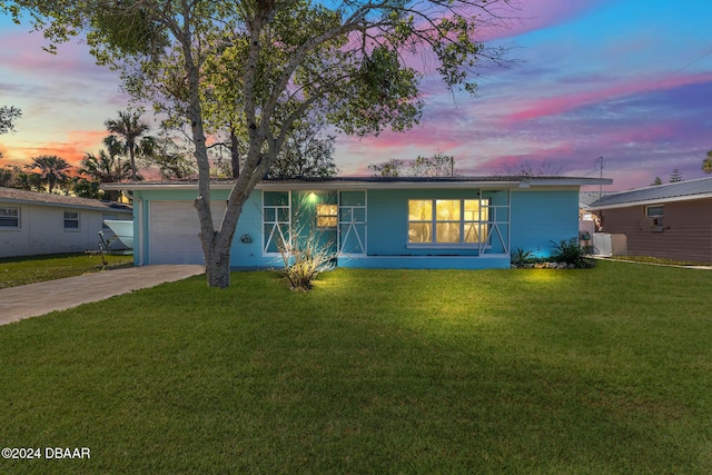 ranch-style home featuring a yard and a garage