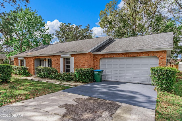 view of front of home with brick siding, driveway, an attached garage, and roof with shingles