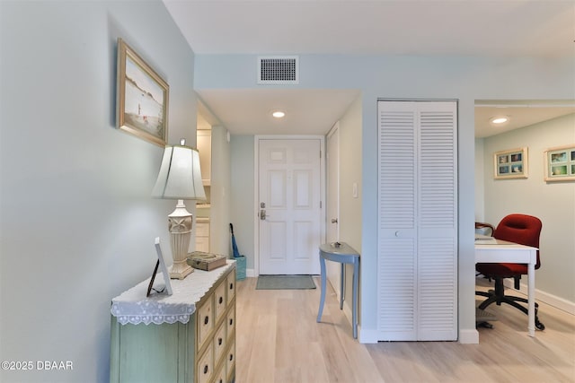 corridor with light wood finished floors, recessed lighting, visible vents, and baseboards