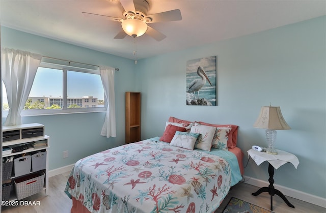 bedroom featuring ceiling fan, wood finished floors, and baseboards