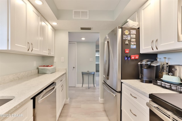 kitchen featuring white cabinets, visible vents, and dishwasher