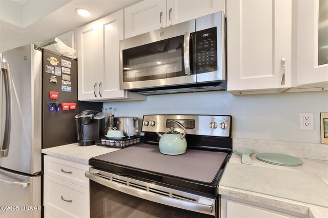 kitchen featuring white cabinets, light stone countertops, and stainless steel appliances