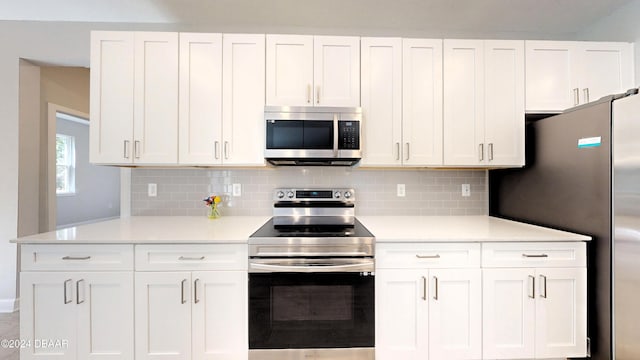 kitchen featuring white cabinets, stainless steel appliances, light countertops, and tasteful backsplash