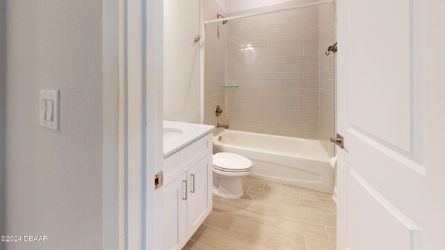 full bathroom with tiled shower / bath, vanity, and toilet