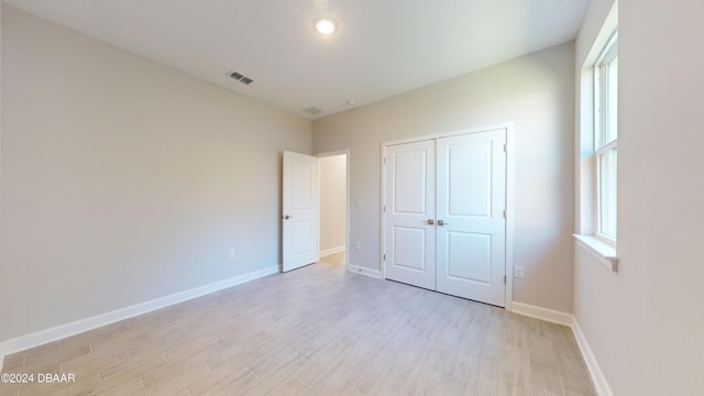 unfurnished bedroom featuring a closet and light hardwood / wood-style floors