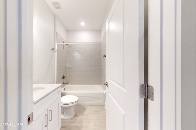 full bathroom featuring tile patterned floors, vanity, toilet, and tiled shower / bath combo