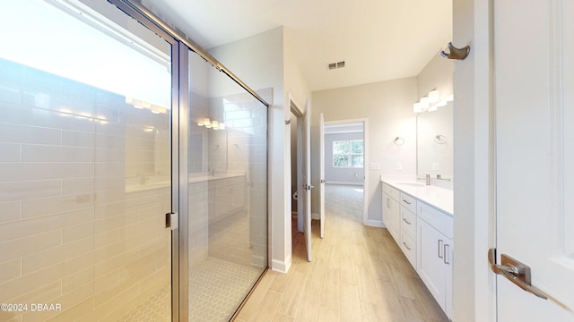 bathroom featuring vanity, hardwood / wood-style flooring, and a shower with shower door