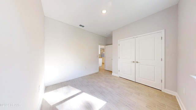 unfurnished bedroom with a closet and light hardwood / wood-style flooring