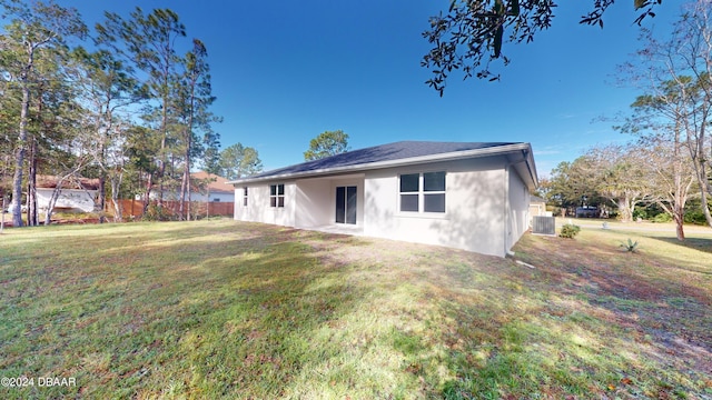 back of property featuring central AC and a yard