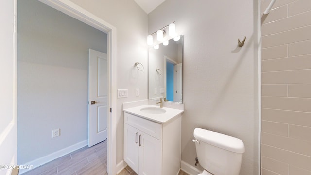 bathroom featuring vanity, hardwood / wood-style flooring, and toilet