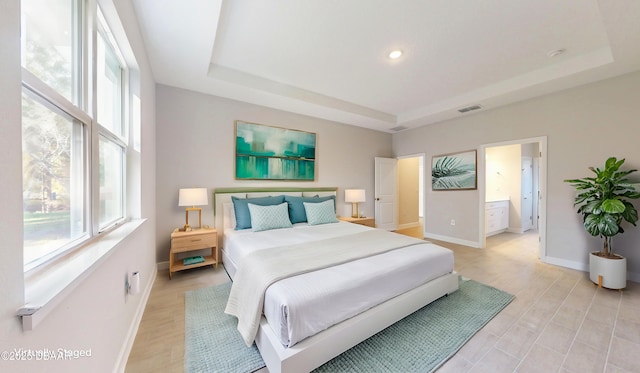 bedroom with baseboards, a raised ceiling, and multiple windows