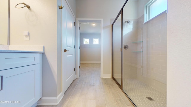 bathroom featuring a tile shower, a wealth of natural light, and vanity