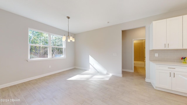 unfurnished dining area with an inviting chandelier