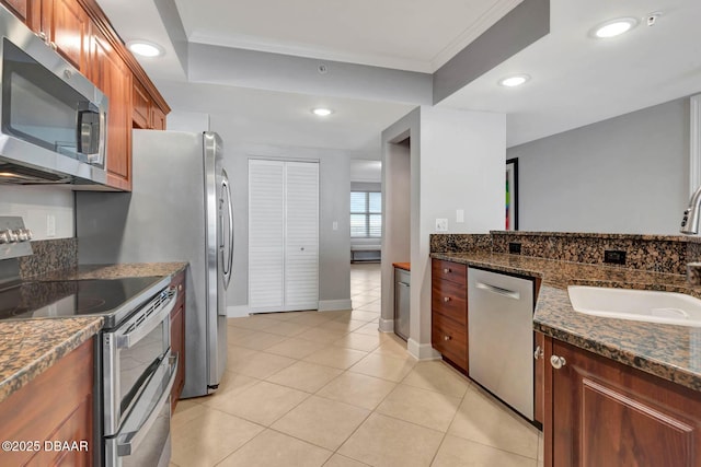 3315 S Atlantic Ave Unit 1606, Daytona Beach Shores, FL 32118 - kitchen featuring appliances with stainless steel finishes, light tile patterned floors, dark stone counters, brown cabinetry, and recessed lighting