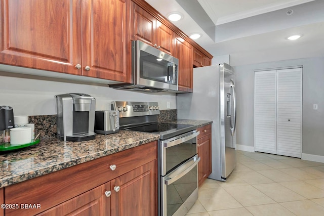 3315 S Atlantic Ave Unit 1606, Daytona Beach Shores, FL 32118 - kitchen with appliances with stainless steel finishes, crown molding, dark stone counters, brown cabinetry, and recessed lighting