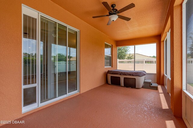 unfurnished sunroom with ceiling fan