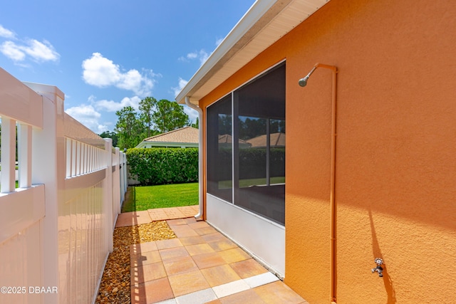 exterior space featuring a sunroom and fence