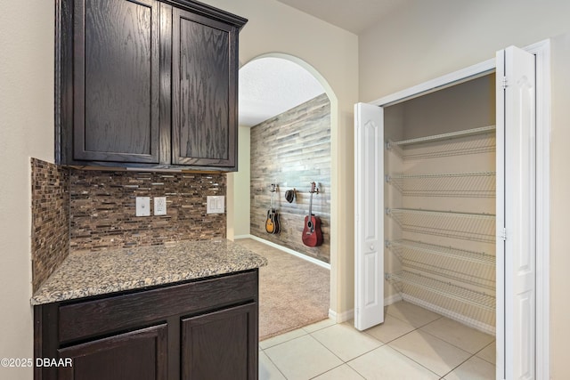 kitchen with dark brown cabinetry, tasteful backsplash, and light tile patterned flooring