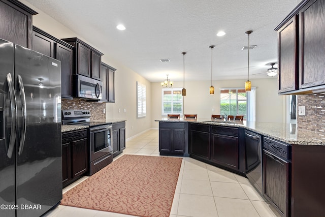 kitchen with appliances with stainless steel finishes, visible vents, light stone counters, and light tile patterned floors