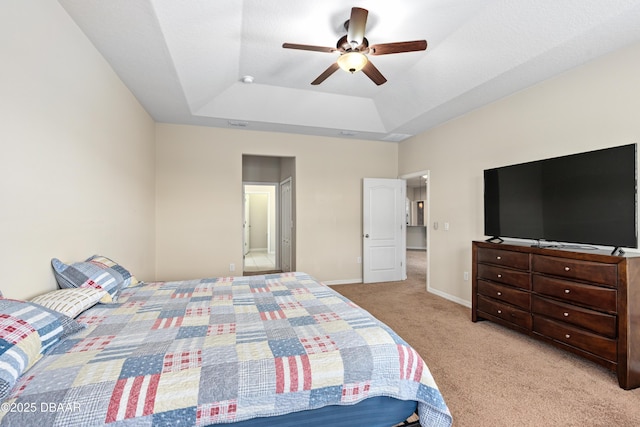 carpeted bedroom featuring baseboards, a tray ceiling, and ceiling fan