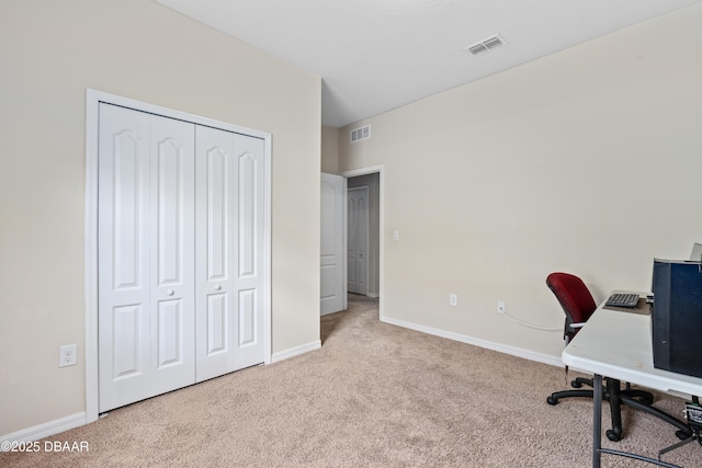 carpeted home office featuring visible vents and baseboards