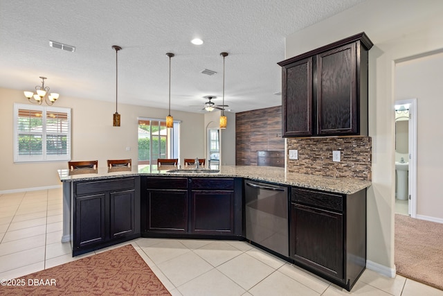 kitchen with backsplash, light tile patterned flooring, a sink, dishwasher, and a peninsula