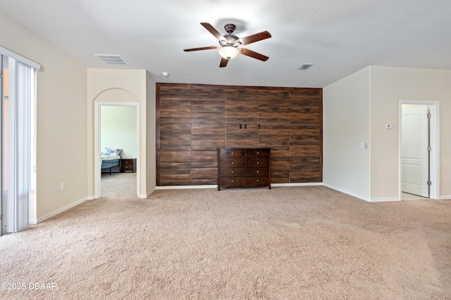 unfurnished living room featuring visible vents, a textured ceiling, and carpet flooring