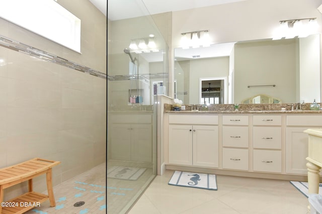 bathroom featuring vanity, tile patterned floors, and a tile shower