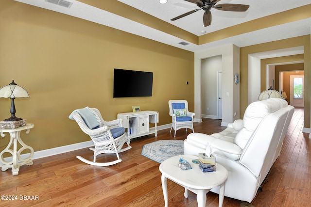 living room featuring wood-type flooring and ceiling fan