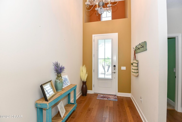 doorway featuring an inviting chandelier, wood-type flooring, and a healthy amount of sunlight