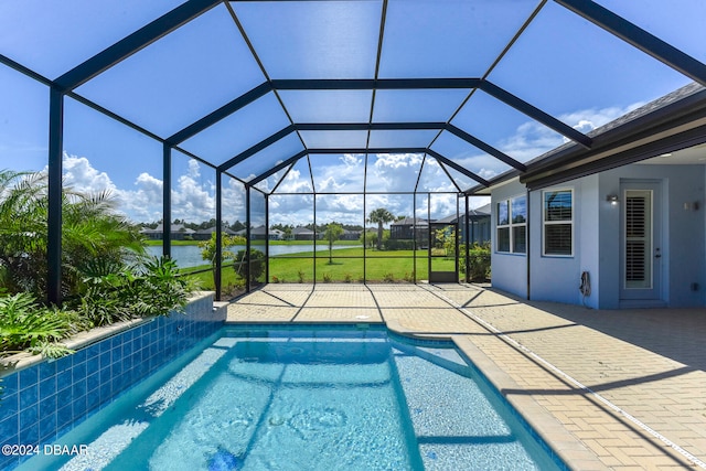 view of pool with a water view, glass enclosure, a lawn, and a patio area