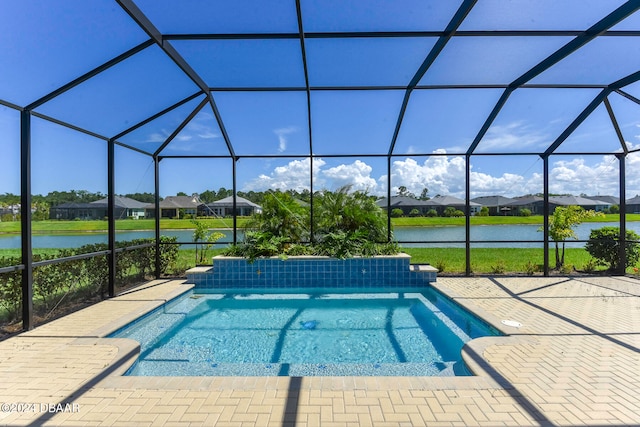 view of pool with a water view, glass enclosure, and a patio area