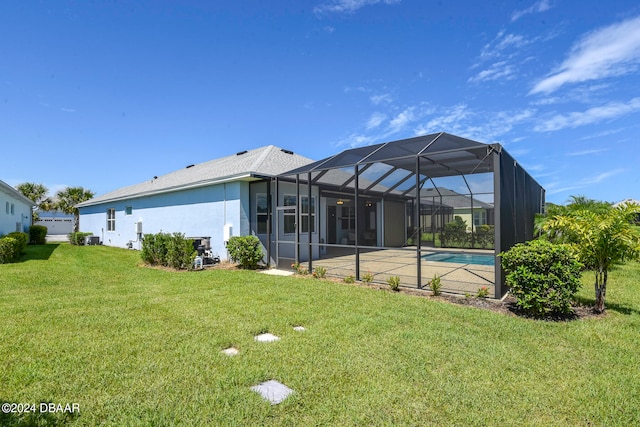 rear view of property with glass enclosure, a yard, and a patio area