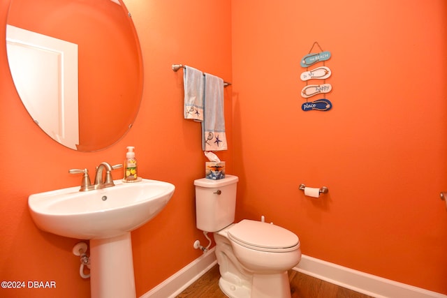 bathroom featuring toilet, sink, and hardwood / wood-style flooring