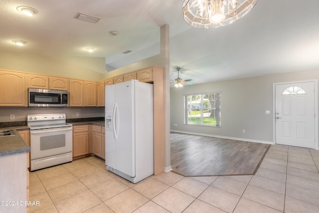 kitchen featuring white appliances, ceiling fan with notable chandelier, hanging light fixtures, vaulted ceiling, and light hardwood / wood-style floors