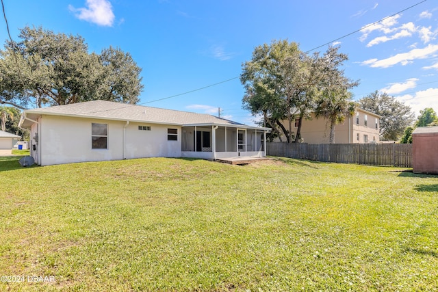 back of property featuring a yard and a sunroom