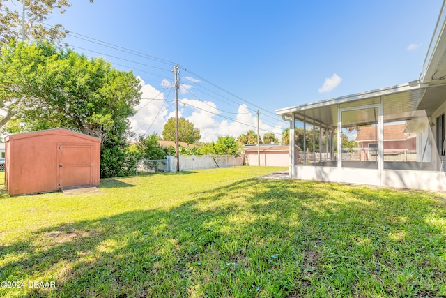 view of yard featuring a sunroom and a storage unit