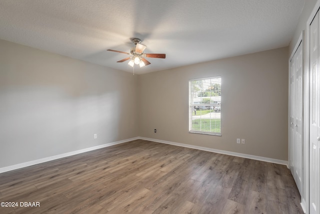 unfurnished bedroom featuring ceiling fan, wood-type flooring, and a textured ceiling