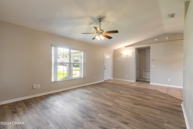 spare room featuring light wood-type flooring, ceiling fan, and lofted ceiling