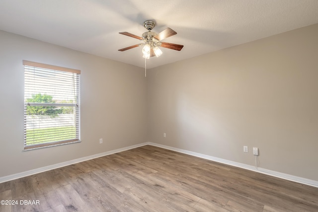 spare room with ceiling fan, a textured ceiling, and light wood-type flooring