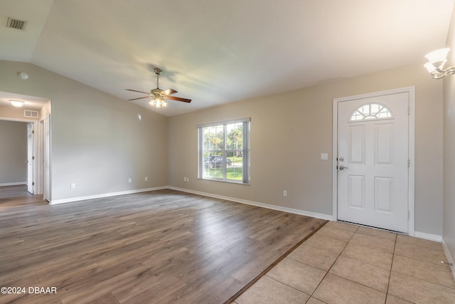 entrance foyer featuring vaulted ceiling, ceiling fan with notable chandelier, and light wood-type flooring