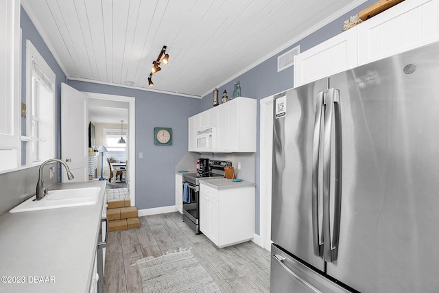 kitchen featuring stainless steel appliances, light hardwood / wood-style floors, white cabinets, and sink