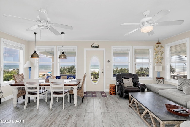 interior space featuring ceiling fan, a water view, and a healthy amount of sunlight