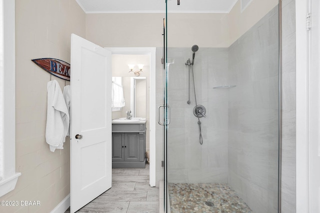 bathroom featuring ornamental molding, hardwood / wood-style floors, vanity, and a shower with door