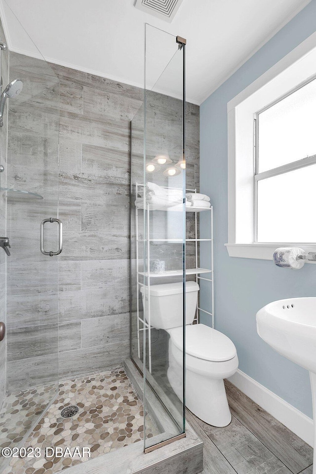 bathroom with toilet and an enclosed shower