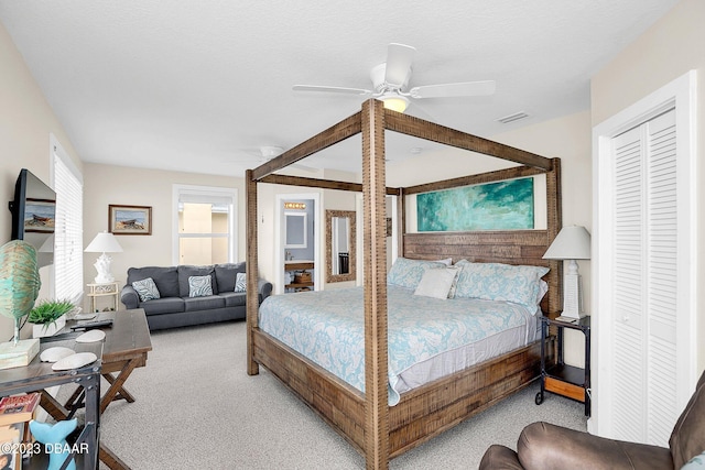 carpeted bedroom featuring ceiling fan and a closet