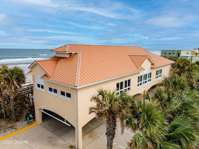 4650 Links Village Dr Unit C402, Ponce Inlet, FL 32127 - view of side of home featuring stucco siding, view of water and beach, and a metal roof