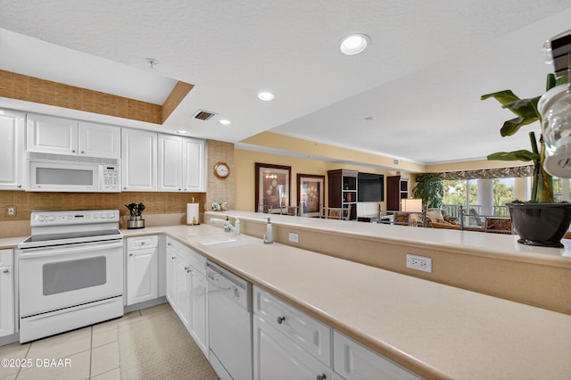 4650 Links Village Dr Unit C402, Ponce Inlet, FL 32127 - kitchen featuring white appliances, white cabinets, tasteful backsplash, light countertops, and light tile patterned flooring